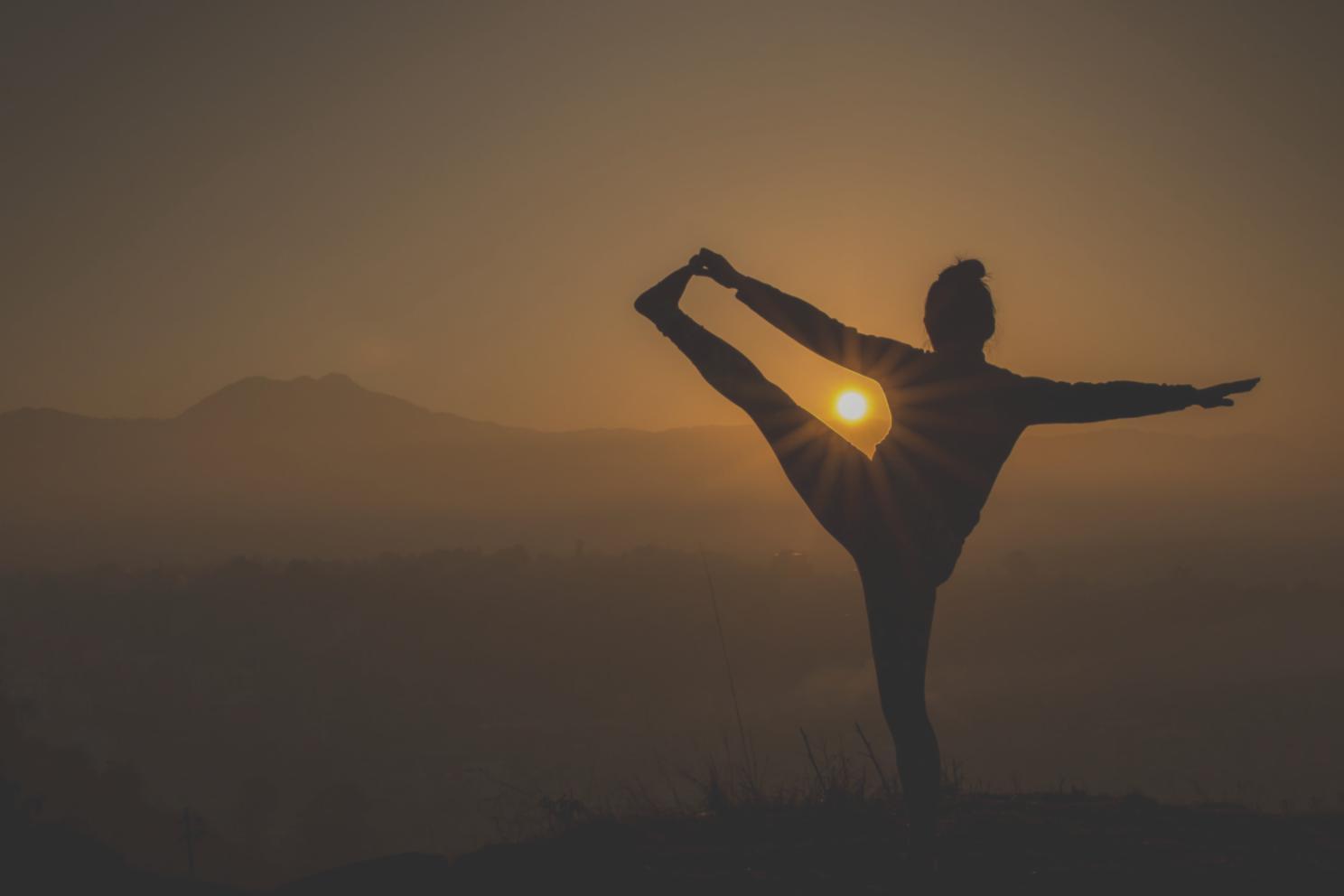 Grupo de estudiantes practicando yoga de fortalecimiento en ambiente de apoyo comunitario